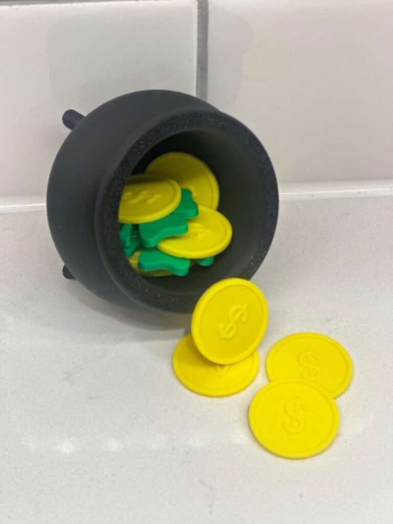 Black pot of gold, with gold coins and green shamrocks party favor.