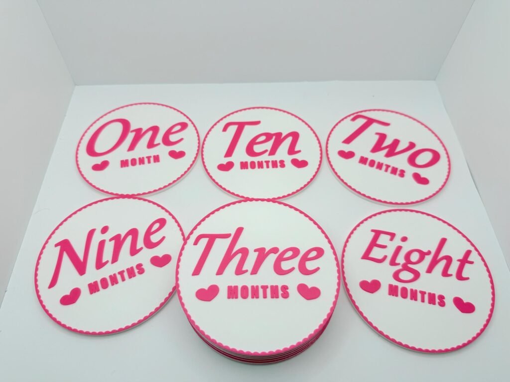 Monthly age markers for children. Pink and white with flowery border.