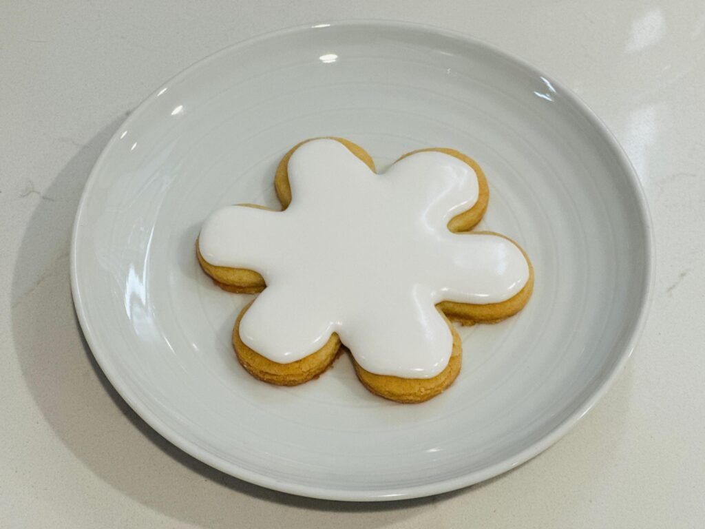 Glazed but unfinished cookie made from Donlon duo's cookie cutter.