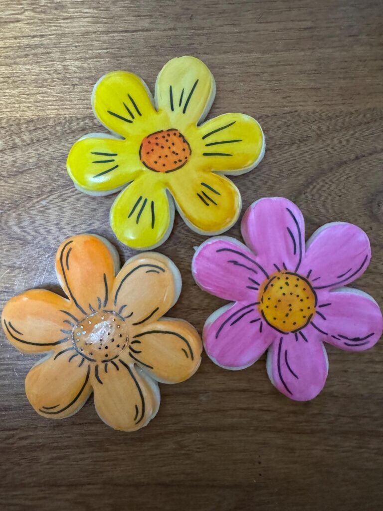 3 Flower cookies, fully decorated and colorful, made with cookie cutter set.