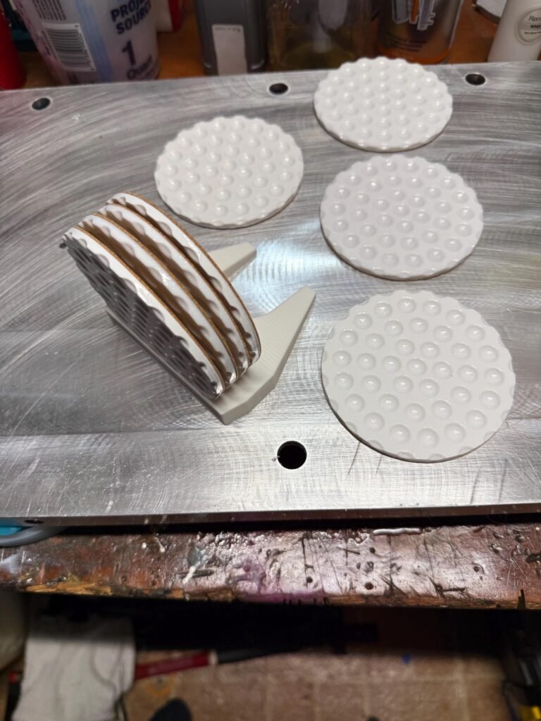 Golf ball drink coasters with holder shaped like a putter.