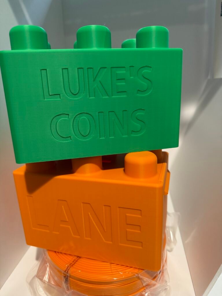 Bambu Green and Pumpkin Orange building block piggy banks that are personalized.